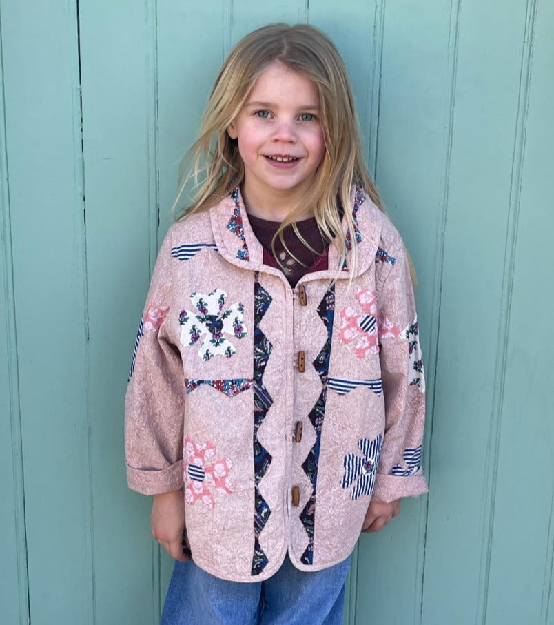 Peach mini patchwork jacket is een populair item uit de collectie van Sissel Eldelbo. De jas heeft een kleine kraag en is gemaakt met zakken aan de voorkant. De jas is gemaakt van 100% katoen met patchwork van een blokprint. Het handgemaakt patchwork is voorzien van een vredesteken en bloemendecoratie. Alle randen zijn mooi bedekt met katoenen randen. 