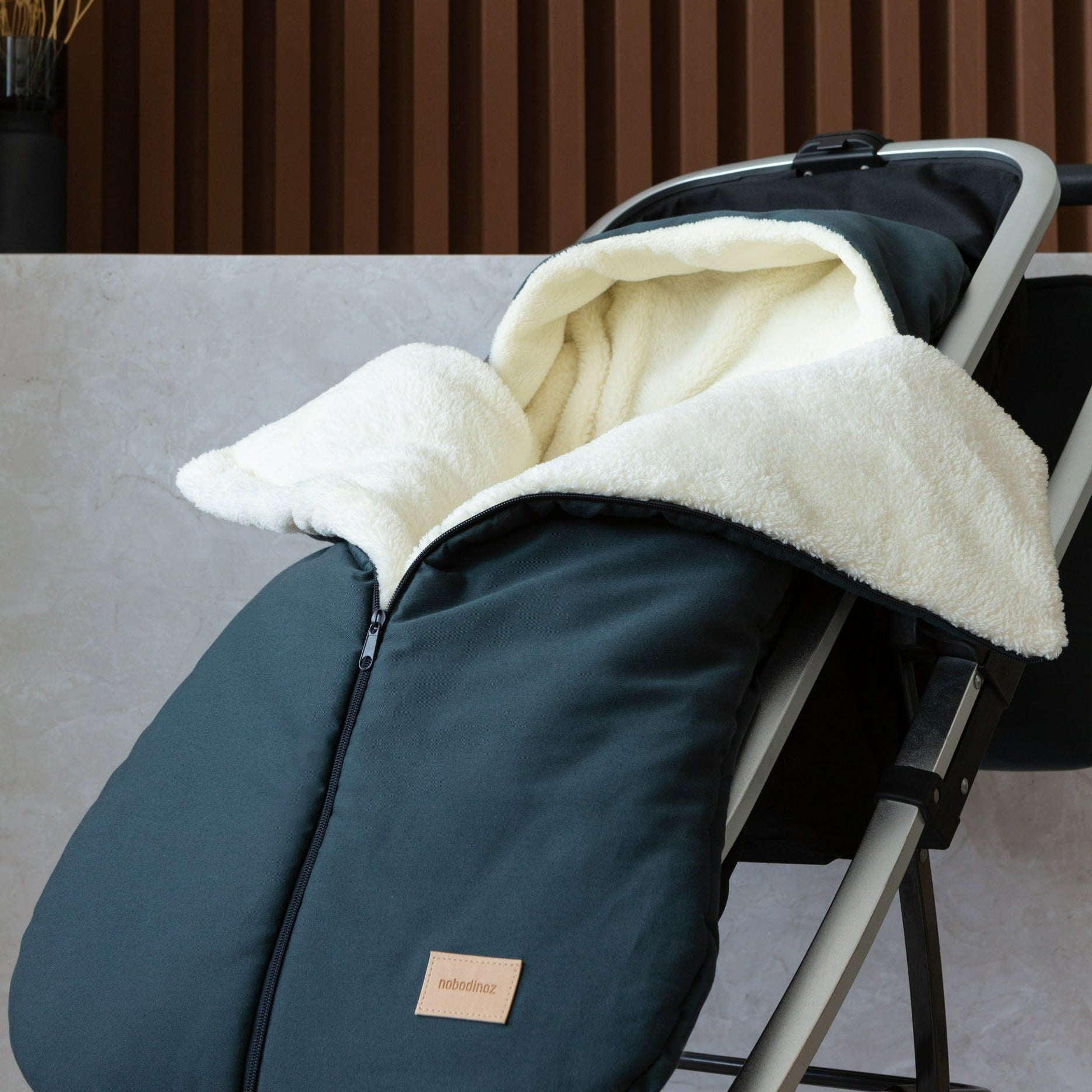 Baby footmuff voor in de kinderwagen in het blauw gevoerd met wol van Nobodinoz.